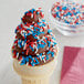 A chocolate ice cream cone with red, white and blue sprinkles.
