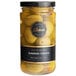 A jar of Belosa Queen Olives with a black label that says Sundried Tomato Stuffed on a yellow surface.