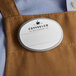 A brown apron with a white oval Cawley nametag.