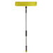A Lavex yellow and black spray mop with a long silver and black handle and a yellow microfiber cloth on it.