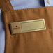 A brown apron with a gold rectangular Cawley nametag.