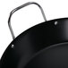 A close-up of a black American Metalcraft wrought iron paella pan with a handle.
