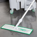 An Unger Damp Mop Pad Holder with a green handle.