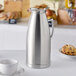 A Choice stainless steel thermal carafe on a table.