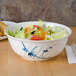 A Blue Bamboo melamine bowl filled with salad and vegetables with chopsticks on a table.