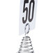 An American Metalcraft spiral table number stand with a white tag and black number on a metal table.