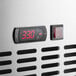 The digital clock on the stainless steel worktop refrigerator.