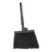 A Carlisle commercial broom with black unflagged bristles and a black handle.