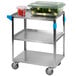 A Carlisle stainless steel utility cart with a container of vegetables on it.