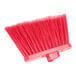 A close-up of a red Carlisle Sparta Duo-Sweep broom with long, pink bristles.