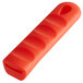A red silicone pan handle sleeve with a hole in it.
