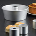 An American Metalcraft anodized aluminum Angel Food cake pan with four muffins in it.