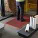 A man standing on a red Choice rubber anti-fatigue floor mat.