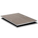 A black and grey reversible drop-in tile with a wooden grain on a table.