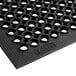 A close up of a Choice black rubber anti-fatigue floor mat with holes in it.