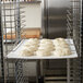 A rack of Winholt plastic proofing boards with dough on them.