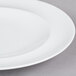 A close-up of an Arcoroc white porcelain side plate with a white rim.