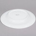 An Arcoroc white porcelain side plate with a small rim.