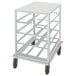 A white metal cart with black wheels and four aluminum shelves.