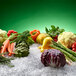 A group of vegetables on ice with a white background.