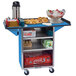 A blue Lakeside stainless steel beverage cart with drop leaves holding ice and soda cans.