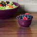 A Fiesta Mulberry china bowl filled with salad and fruit.