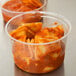 A Fabri-Kal clear plastic deli container filled with pasta and red sauce.