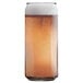 An Arcoroc tall can cooler glass filled with beer and foam.