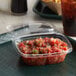 A Dart plastic container with salsa in it on a tray.
