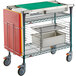 A green and silver Metro PrepMate cart with trays on it.