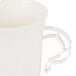 A close up of a WNA Comet ivory plastic coffee cup with a handle.