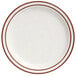 A white narrow rim stoneware plate with brown speckles and bands.