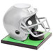A gray football helmet on a green Beer Tube surface.