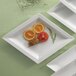 A CAC porcelain serving platter with oranges and tomatoes on it.