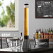A Beer Tubes carbon conic tall beer tower on a table with a glass mug.