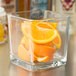 A Libbey glass container filled with orange slices on a counter.