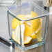 A Libbey glass container filled with lemon wedges on a kitchen counter.