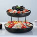 An American Metalcraft black rubberized pizza stand holding a bowl of seafood on ice.