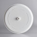 A close up of a white circular GET Madison Avenue display tray with a hole in it.