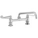 A chrome Equip by T&S deck-mounted faucet with wrist handles and a swing spout.