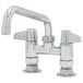 A chrome Equip by T&S deck-mounted faucet with lever handles and a swing spout.