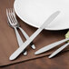 A Walco stainless steel dinner fork and knife on a plate.