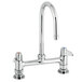 A chrome Equip by T&amp;S deck-mounted faucet with two gooseneck spouts and lever handles.