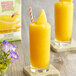 A glass of yellow DaVinci Gourmet Mango Mania smoothie with a straw and fruit slice.