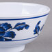 A close up of a Thunder Group Lotus melamine rice bowl with blue and white flowers.