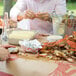 A crab patterned table cover on a table with crabs and food.