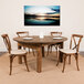 A Flash Furniture solid pine round folding farm table with plates on it surrounded by chairs.