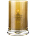 A Sterno gold votive candle in a glass holder.