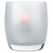 A close up of a white glass vase with a red light inside.
