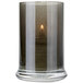 A Sterno glass votive with a lit candle inside.
